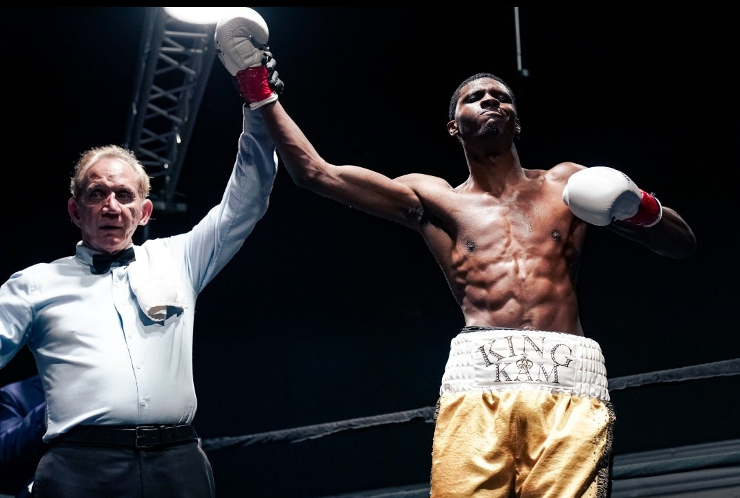 Boxer celebrating a victory with a referee in a boxing ring